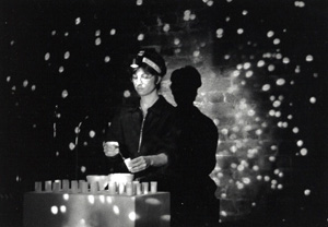 Black and white photograph of Thea performing in front of a speckled backdrop.
